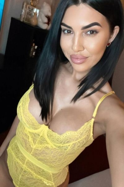 A selfie of brunette escort Devon wearing a sexy yellow body