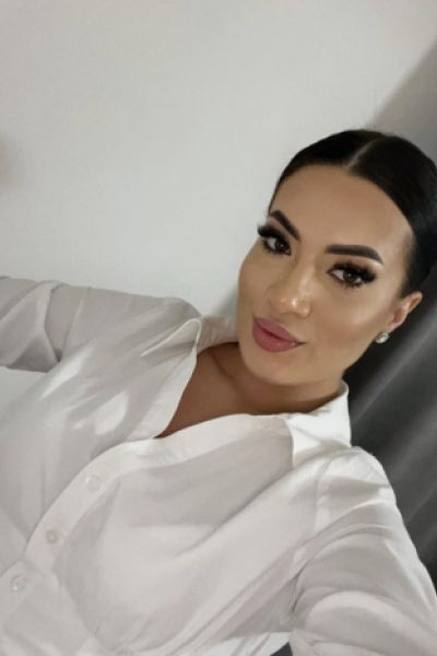 A selfie of a very sexy brunette escort wearing a white shirt 